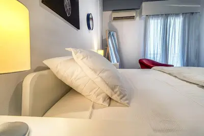 a bedroom with a white bed with a pillow on it at Beautiful and cozy studio next to Athens center in Athens