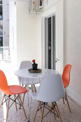 a white table with four chairs and a table with a plant on it at Acropolis Exclusive Apartment in Athens