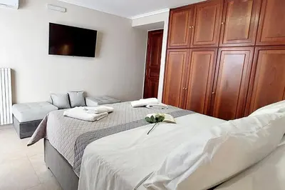 a bedroom with two beds and a flat screen tv at ACROPOLIS GATE in Athens