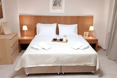 a bedroom with a large white bed with two lamps at ACROPOLIS GATE in Athens