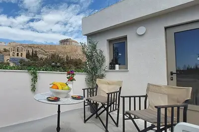 a patio with a table and chairs on a balcony at ACROPOLIS GATE in Athens