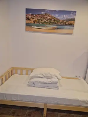 a bed in a room with a picture on the wall at Quiet Studio with Athens View in Athens