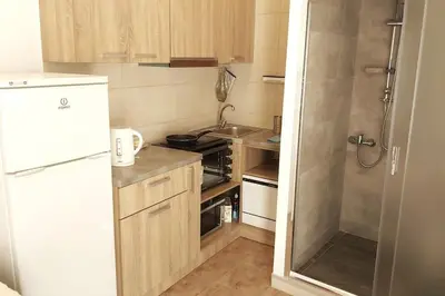a small kitchen with a sink and a refrigerator at Quiet Studio with Athens View in Athens