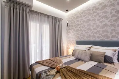 a bedroom with a bed with a large window at Luxurious apt near Ampelokipoi Metro station in Athens