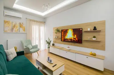 a living room with a fireplace on the wall at Luxurious apt near Ampelokipoi Metro station in Athens