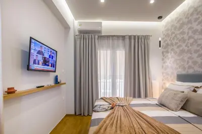 a bedroom with a bed and a tv on a wall at Luxurious apt near Ampelokipoi Metro station in Athens