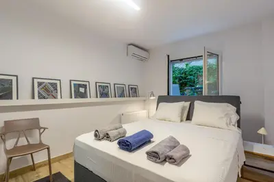 a bedroom with a white bed with two pillows on it at A newly fully renovated studio in Athens