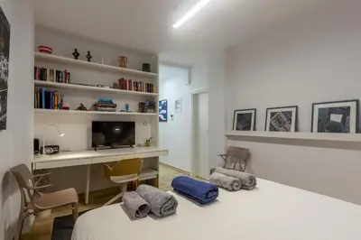 a bedroom with a bed and a desk and a tv at A newly fully renovated studio in Athens