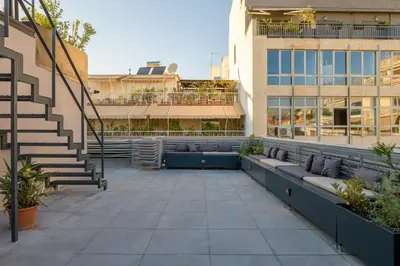 a courtyard of a building with benches and stairs at Your 4 bdrm Dream House Acropolis View & Jacuzzi in Athens