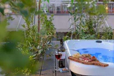 a bottle of wine and a plate of food next to a bath tub at Your 4 bdrm Dream House Acropolis View & Jacuzzi in Athens