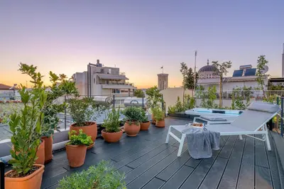 a balcony with plants and a chair and a table at Your 4 bdrm Dream House Acropolis View & Jacuzzi in Athens