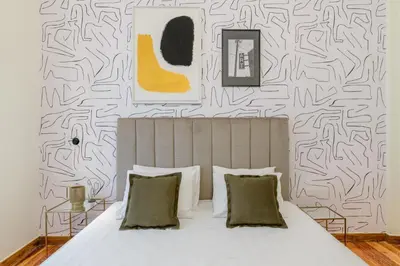 a bedroom with a white bed with a black and white wallpaper at Your 4 bdrm Dream House Acropolis View & Jacuzzi in Athens