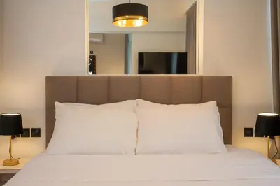 a large bed with white pillows and a large mirror at Dema Luxury Suites - Perikleous E6 in Athens
