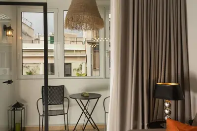 a room with a table and a chair and a window at Dema Luxury Suites - Perikleous E6 in Athens