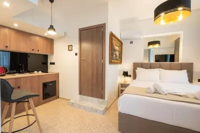 a bedroom with a bed and a desk and a kitchen at Dema Luxury Suites - Perikleous E6 in Athens