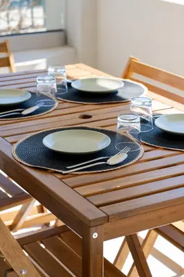 a wooden table with plates and glasses on it at Be Home Sea View in Porto Rafti
