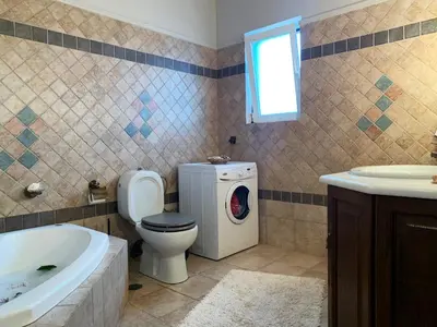 a bathroom with a toilet and a washing machine at Vintage Manor in Anavissos