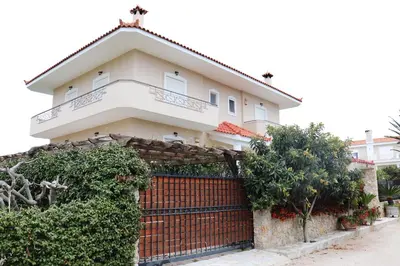 a house with a red fence in front of it at Vintage Manor in Anavissos