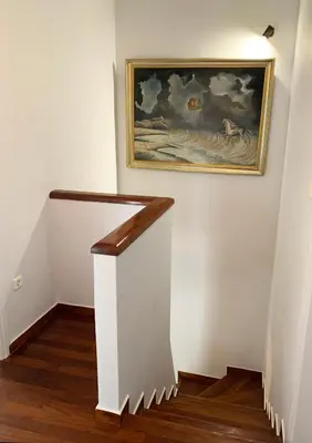a hallway with a painting on the wall and a stairway at Vintage Manor in Anavissos