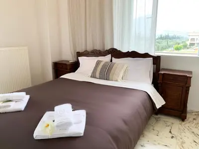 a bedroom with a bed with towels and a window at Vintage Manor in Anavissos