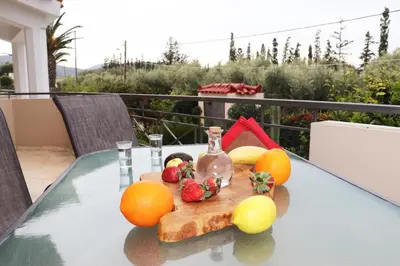 a glass table with fruit on it on a balcony at Vintage Manor in Anavissos