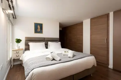 a bedroom with a large bed with two towels on it at Modern Two Level Apartment in the Heart of Athens in Athens