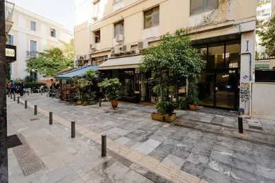 an empty street with trees and a building at Modern Two Level Apartment in the Heart of Athens in Athens