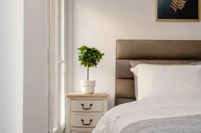 a bedroom with a bed and a plant on a night stand at Modern Two Level Apartment in the Heart of Athens in Athens