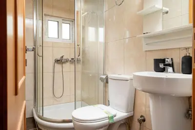 a bathroom with a shower and a toilet and a sink at Modern Two Level Apartment in the Heart of Athens in Athens