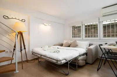 a white room with a bed and a table at Modern Two Level Apartment in the Heart of Athens in Athens