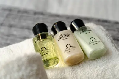 three bottles of soap sitting on a towel at Modern Two Level Apartment in the Heart of Athens in Athens