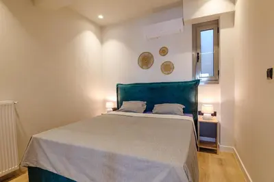 a bedroom with a bed with a green headboard and a window at Goudi 4th Floor Greece Apartments in Athens
