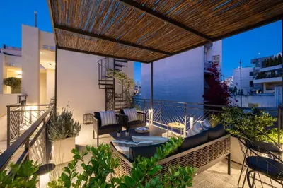a balcony with chairs and tables on a building at Athenian Island Project in Athens
