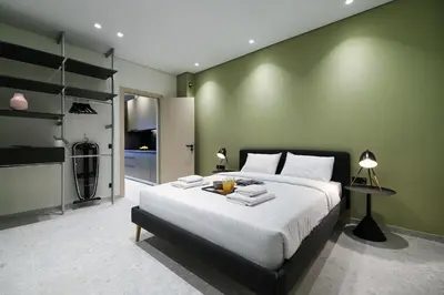 a bedroom with a large bed and a green wall at Athenian Island Project in Athens