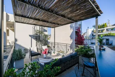 an outdoor patio with a wooden pergola at Athenian Island Project in Athens