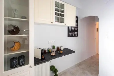 a kitchen with white cabinets and a black counter top at Blue Ark Wanderlust in Athens