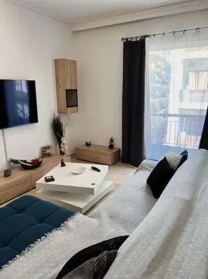 a living room with a couch and a tv at Minimal 3BR Apartment in Athens in Athens