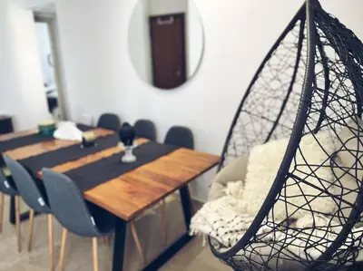 a dining room with a table and chairs and a swing at Minimal 3BR Apartment in Athens in Athens