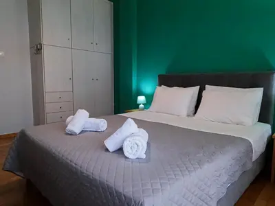 a bed with towels on it with a green wall at Comfortable apt, next to Archeological museum! in Athens