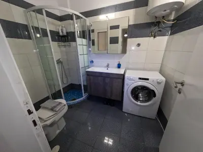 a bathroom with a washing machine and a toilet at Comfortable apt, next to Archeological museum! in Athens