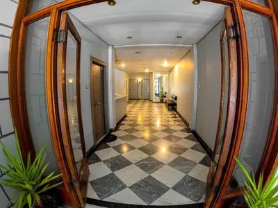 a hallway with a mirror and a checkered floor at Comfortable apt, next to Archeological museum! in Athens