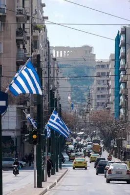 a busy city street with cars and american flags at Comfortable apt, next to Archeological museum! in Athens