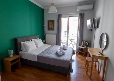 a bedroom with a bed and a green wall at Comfortable apt, next to Archeological museum! in Athens
