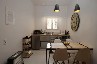 a kitchen with a table and chairs in a room at Athens City Apartment the Nest of Filoxenia in Athens