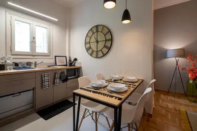 a kitchen with a table and chairs in a room at Athens City Apartment the Nest of Filoxenia in Athens