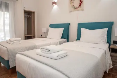 a room with two beds with towels on them at Esperidon Luxury Apartment Glyfada in Athens