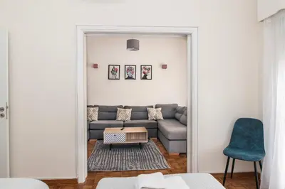 a living room with a couch and a blue chair at Esperidon Luxury Apartment Glyfada in Athens