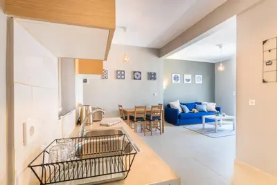 a kitchen and living room with a blue couch at A modern and spacious flat in Gazi in Athens
