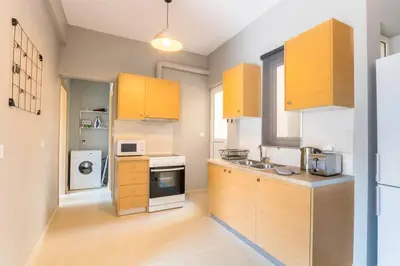 a kitchen with wooden cabinets and a sink and a microwave at A modern and spacious flat in Gazi in Athens