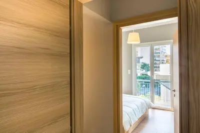 a bedroom with a sliding door with a bed and a window at A modern and spacious flat in Gazi in Athens